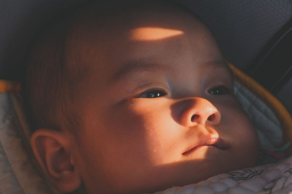Bebe deitado tranquilamente no bebe conforto, banhado por luz suave