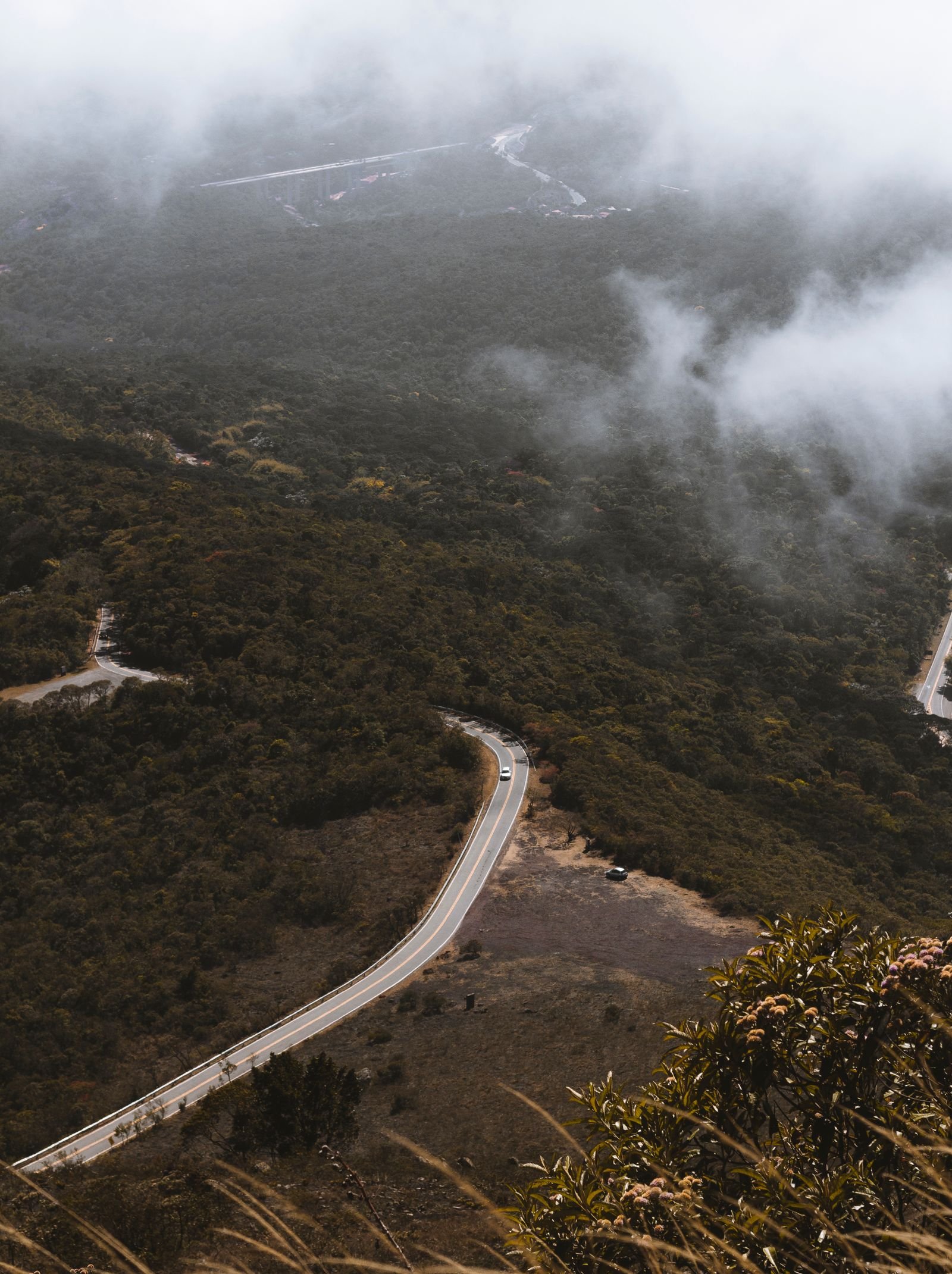 Vista aérea de uma estrada sinuosa cercada por vegetação densa em Minas Gerais, Brasil
