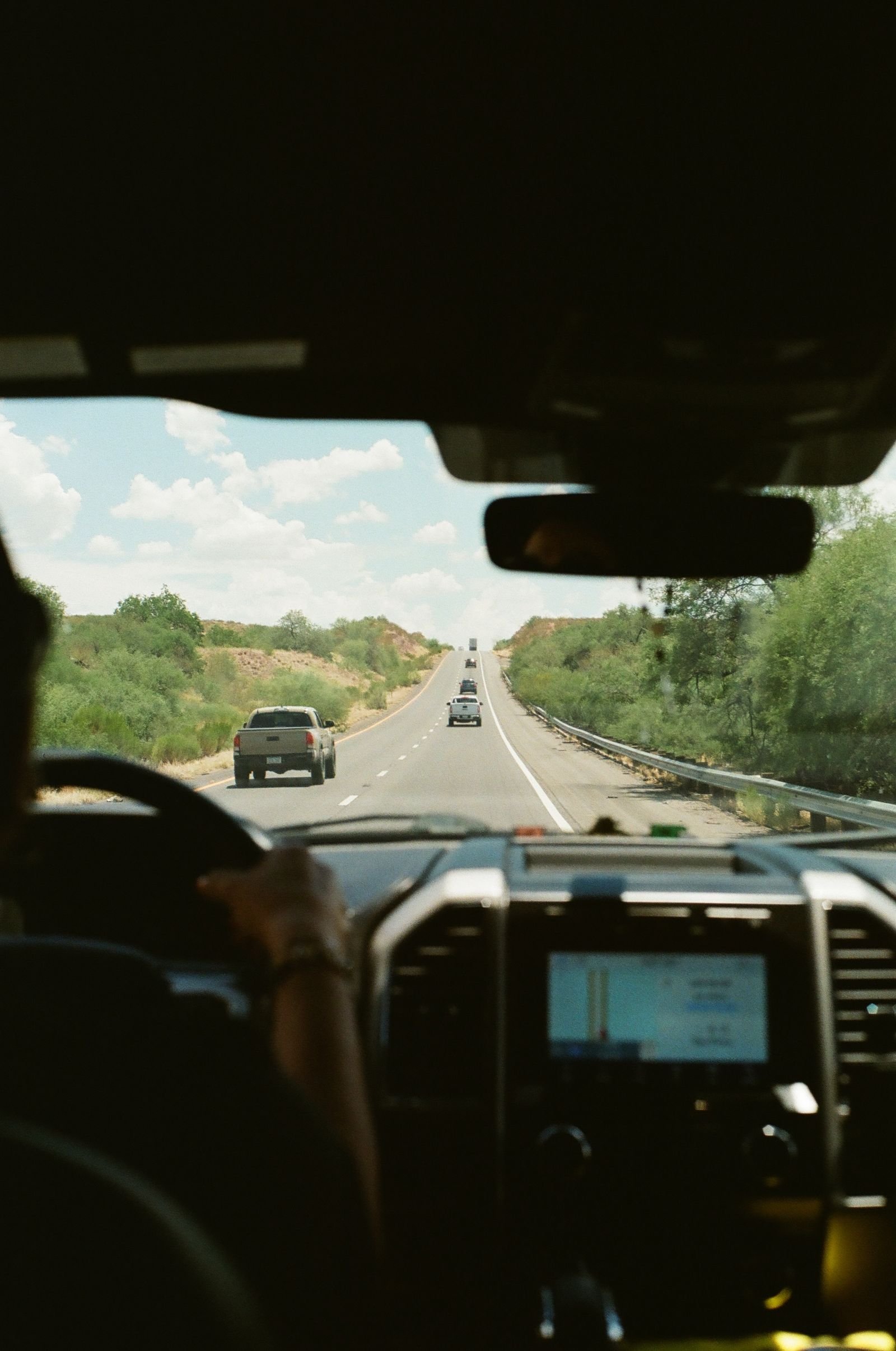 Vista de dentro do carro dirigindo por uma rodovia cênica sob céu claro